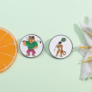 Cartoon dog and tiger golf enamel pins with round metal frames on a green background