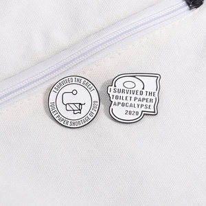 Detailed view of toilet paper roll enamel pins on white canvas bag fabric background