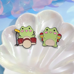 Creative green frog enamel pin set featuring cute musicians playing drums and maracas
