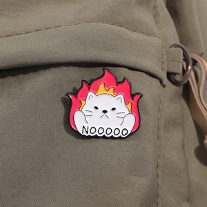 Detail einer lustigen weißen Katzen-Emaille-Anstecknadel mit NOOOOO-Text und Flammen