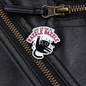 Détail de la broche chat émaillée avec texte GIVE 'EM THE OL' RAZZLE DAZZLE sur cuir