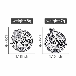 Detail view of round black skull enamel pins with motivational quotes and size specifications