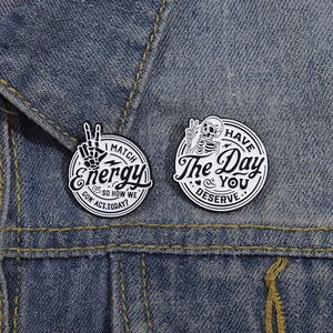Funny skull enamel pins with motivational quotes on blue denim jacket collar