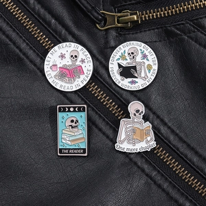 Detailed view of colorful skeleton enamel pins with reading quotes on a black leather jacket