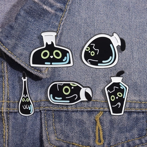 Five black cat potion bottle enamel pins displayed on a blue denim fabric background