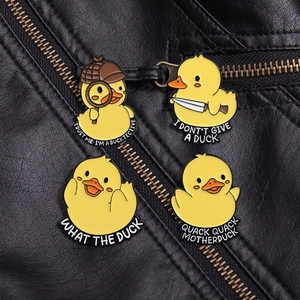 Close-up of four yellow duck enamel pins on black leather jacket showing fine metal detail