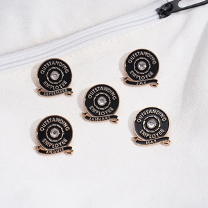Macro detail of black and gold outstanding employee badges on white canvas fabric