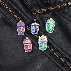 Macro shot of cartoon boba tea enamel pins pinned on a black leather jacket collar