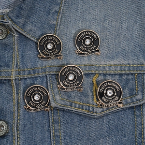 Detailed view of Outstanding Employee lapel pin with rhinestones on denim jacket