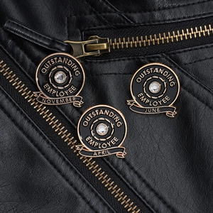 Detailed macro view of black enamel month badges with rhinestones on black leather