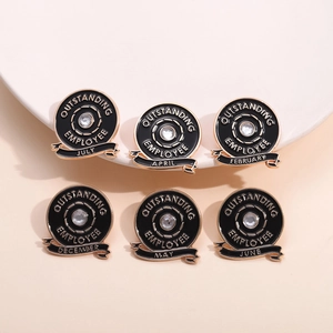 Detail of round black enamel employee award brooches with gold plating and rhinestones
