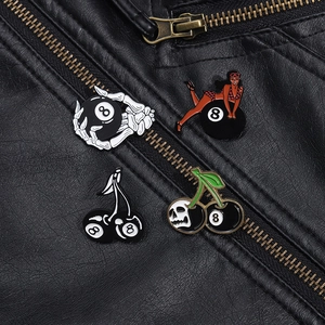 Detail of punk enamel pins on black leather jacket featuring skull and 8-ball designs