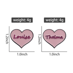 Detailed size view of pink heart enamel pins with Louise and Thelma script engraving