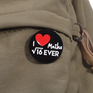 Detail of round enamel pin with 'I love math' design on green canvas bag fabric