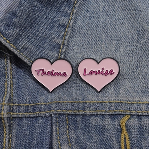 Pink heart enamel brooch set featuring Thelma and Louise text on denim jacket