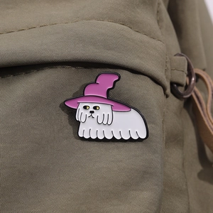 Gros plan d'une broche chien avec chapeau de sorcier rose sur un sac en toile olive