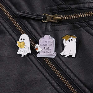 Close-up of three ghost and books enamel pins set on a black leather jacket texture
