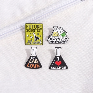 Science theme enamel pin set with beaker and flask designs on a white canvas bag