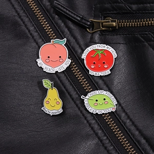 Cute fruit enamel pins set featuring peach, tomato and pear on a black leather jacket