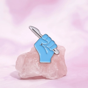 Blue medical glove enamel brooch holding a silver scalpel for doctor costume accessory