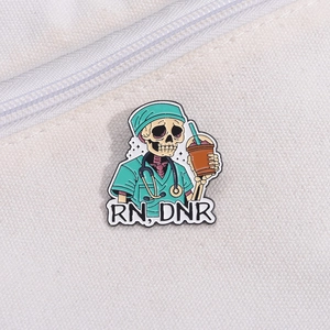 Detail of RN DNR enamel pin featuring a skeleton nurse holding an iced coffee on canvas