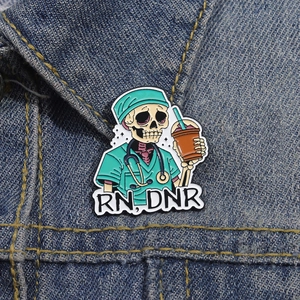 Skeleton nurse enamel pin with stethoscope and cold drink on blue denim background