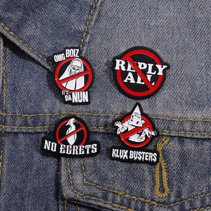 Set of 4 subculture enamel pins including The Nun and No Egrets on blue denim fabric