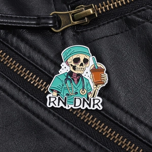 Cartoon skeleton nurse enamel pin with RN DNR lettering on black leather jacket background