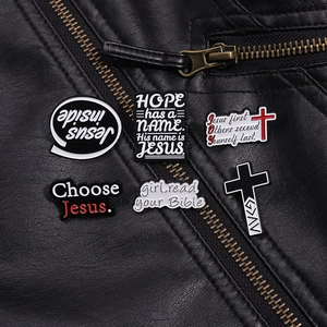 Broches en émail avec croix et devises religieuses sur une veste en cuir noir