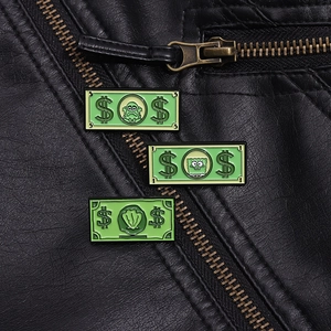 Detailed view of three banknote enamel pins on a black leather jacket with cartoon icons