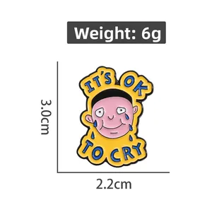 Detailed macro view of yellow enamel pin featuring It's OK TO CRY cartoon face design