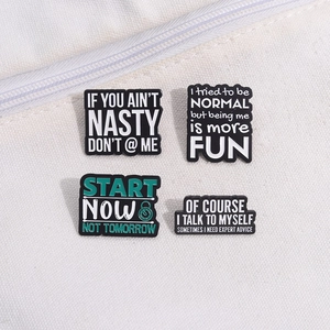 Set of 4 enamel pins with motivational quotes displayed on white canvas fabric