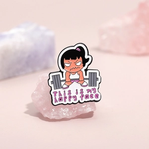 Broche de esmalte divertido de niña pesista con frase sobre fondo rosa pastel