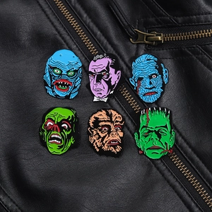 Detail of six classic horror movie enamel pins pinned on a black leather jacket