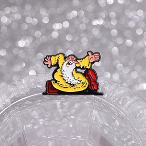 Macro view of cartoon wizard enamel pin with white beard on glass edge with bokeh effect