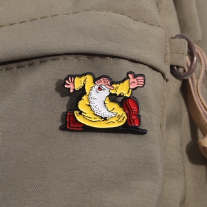Detailed close-up of cartoon Mr. Natural enamel pin on a green canvas backpack