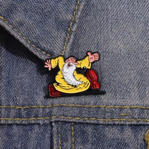Enamel pin of cartoon wizard in yellow robe pinned on blue denim fabric background