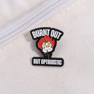 Burnt Out But Optimistic enamel pin with marshmallow design on white canvas bag