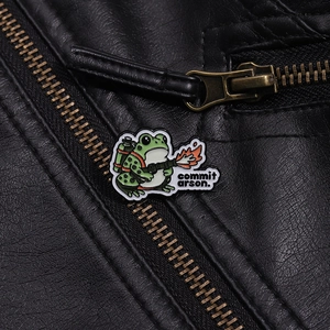 Détail du pin's grenouille humoristique sur un blouson en cuir noir avec gravure