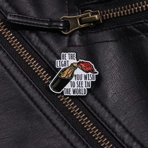 Detail der Emaille-Anstecknadel mit brennender Flasche auf schwarzer Lederjacke