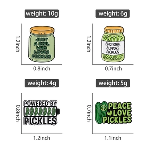 Macro view of cartoon pickle enamel pin set with weight and size details in inches