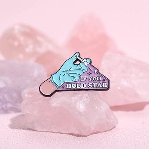 Cartoon enamel pin of a gloved hand holding a syringe with the text If You Hold Stab
