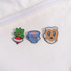 Lot de 3 pin's émaillés The Office avec betterave Schrute Farms et Pretzel Day