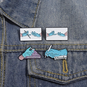 Cartoon medical enamel pin set with blue surgical gloves and steady scalpel on denim