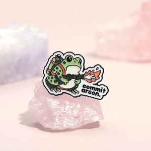 Funny green frog enamel pin with flame thrower and commit arson text on pink crystals