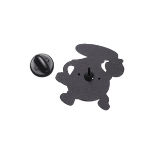 Detail view showing the matte black metal back of the cartoon pin with a rubber clutch