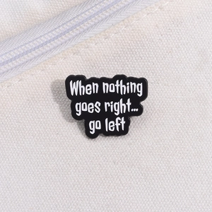 Detail of inspirational 'Go Left' enamel pin on white canvas bag with zipper texture