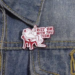 Creative enamel frog pin featuring white frog on red chair pinned to denim fabric
