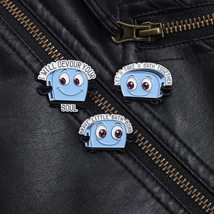Detailed close-up of blue enamel toaster pins with dark humor text on a black leather jacket