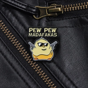 Detail of funny yellow chick enamel pin with guns pinned on a black leather jacket